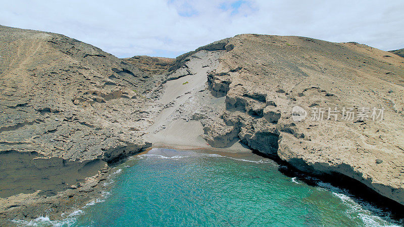 Aerial view of the hidden cove beach "La Rajita" at the natural reserve of "Montaña Pelada" in Tenerife (Canary Islands). Drone shot